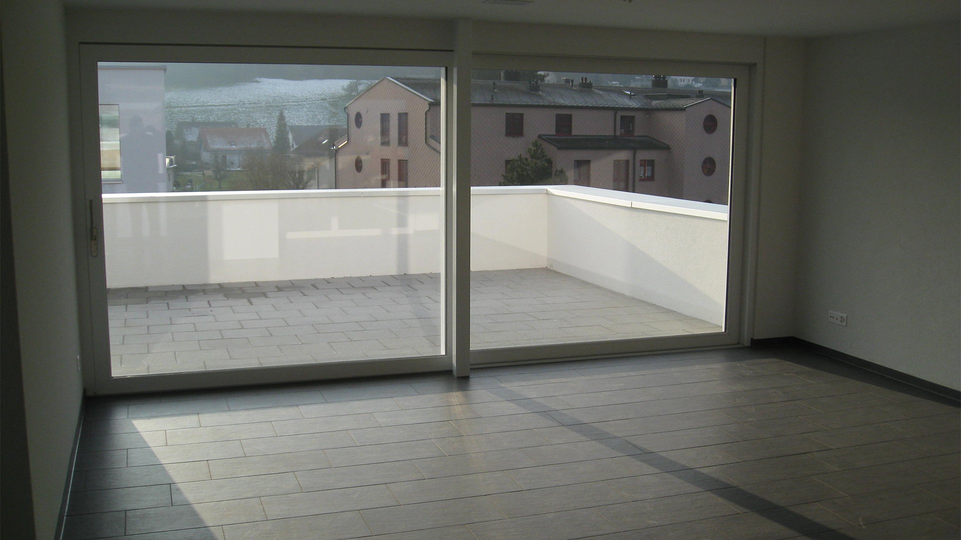 Raum mit Großer Fensterfront und Terrasse mit Blick in die weite 